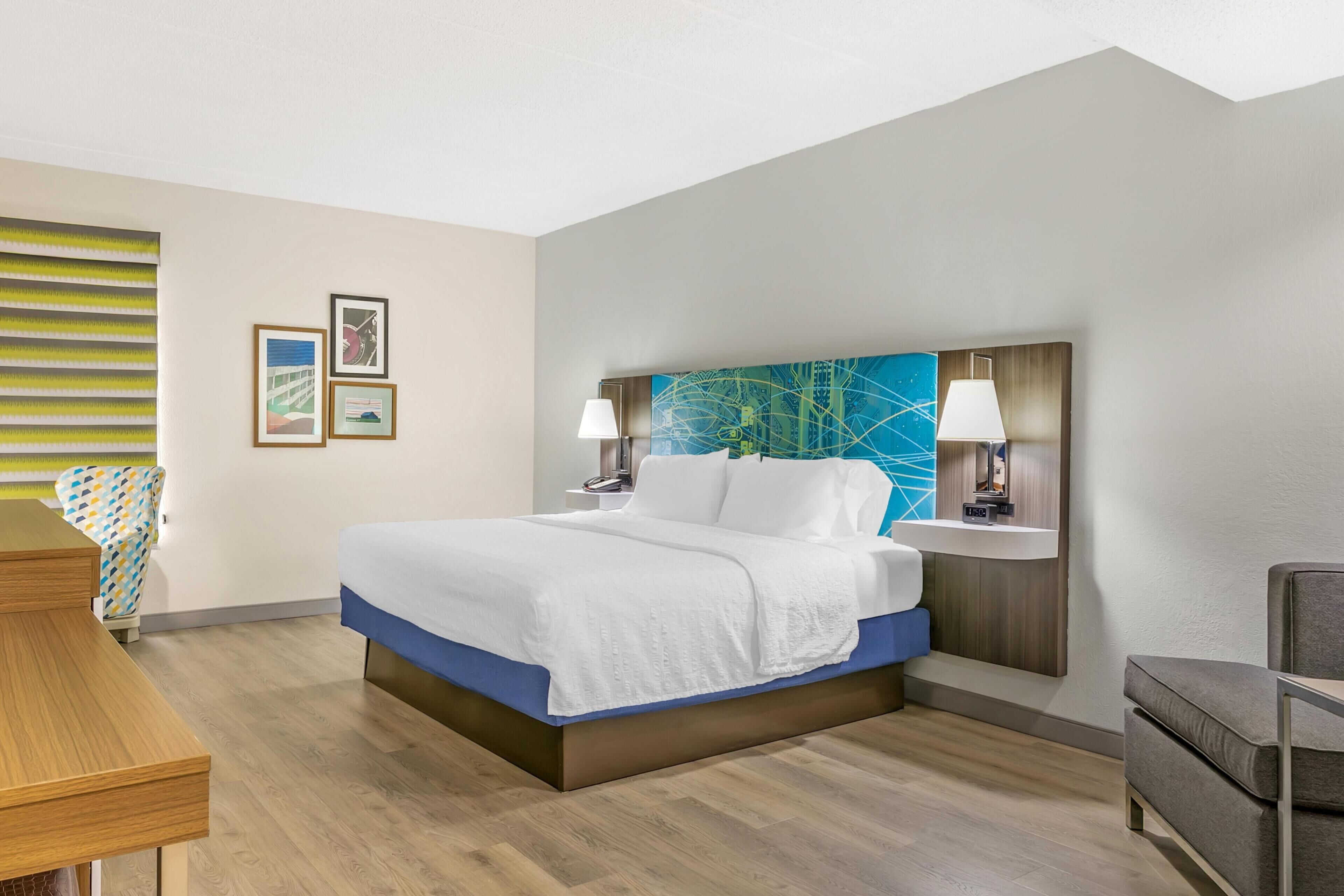 Ein Hotelzimmer mit Bett, Nachttischen, Schreibtisch und Stuhl.