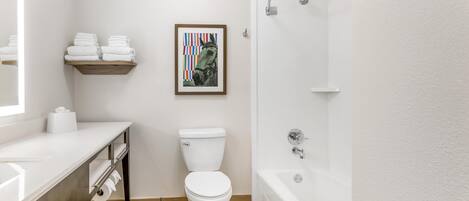 Un baño moderno con inodoro, lavamanos y bañera.