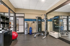 A gym with exercise equipment, a red exercise ball, and a water bottle. - Hampton Inn Richmond (Richmond)