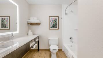 A modern bathroom with a sink, toilet, and bathtub.