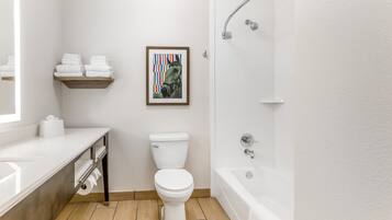 A modern bathroom with a toilet, sink, and bathtub.