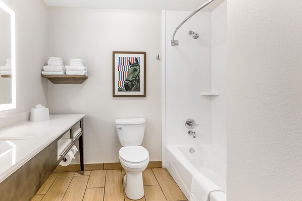 A modern bathroom with a toilet, sink, and bathtub.