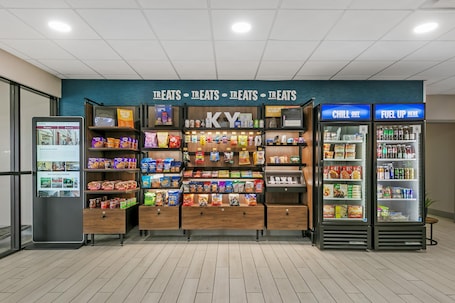 A snack kiosk with a variety of packaged snacks, a digital menu display, and two beverage dispensers labeled 'CHILL OUT' and 'FUEL UP HERE'.