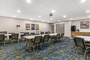 A conference room with tables and chairs, a projector, and artwork on the walls. - Hampton Inn Richmond (Richmond)