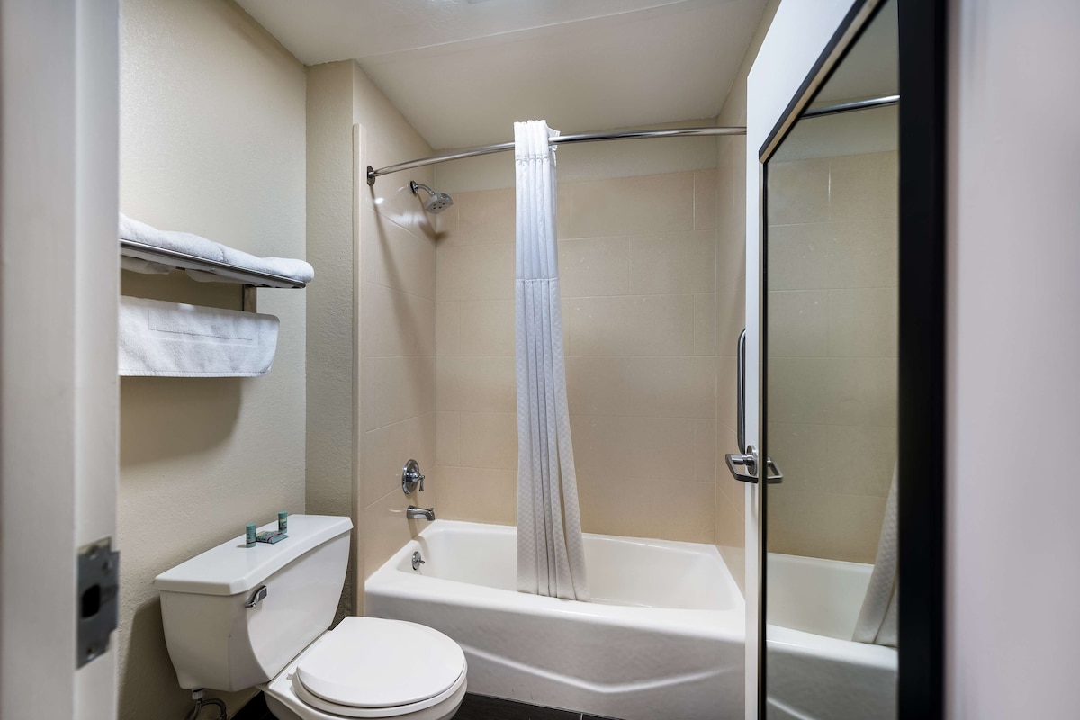 A bathroom with a toilet, a bathtub, and a shower.