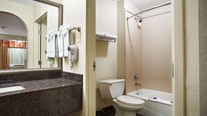 A bathroom with a marble countertop, a toilet, a bathtub, and a hairdryer on the wall. - Best Western Minden Inn (Minden)