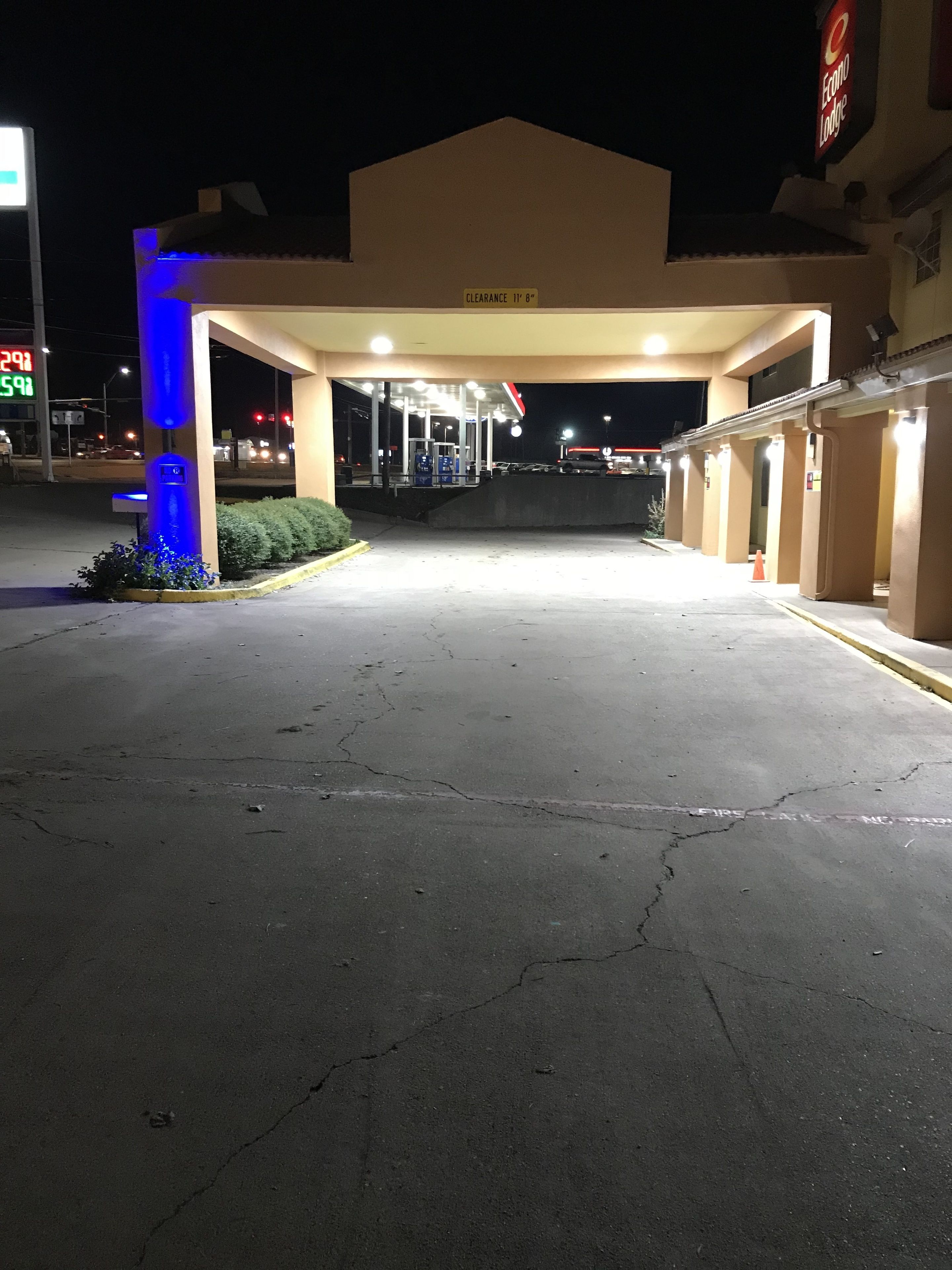 A hotel entrance with a covered parking area, a sign indicating a clearance of 11' 8", and a visible entrance to the hotel.