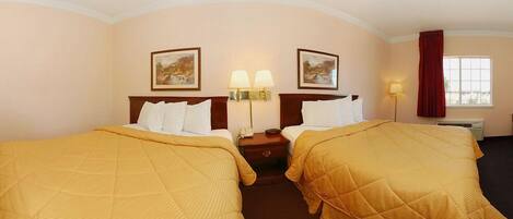 A hotel room with two beds, a nightstand with lamps, a window with curtains, and two wall-mounted paintings.