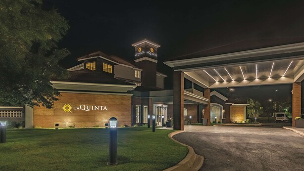 A hotel entrance with a sign reading "La Quinta" and a well-lit driveway. - La Quinta Inn & Suites by Wyndham Oklahoma City Norman (Norman)