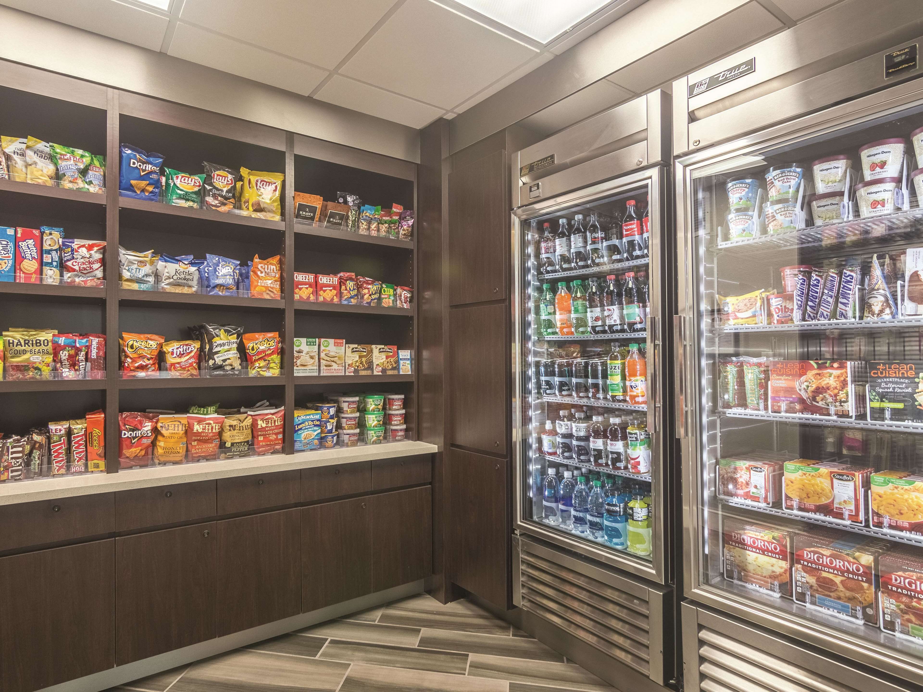 A snack and beverage section with shelves stocked with various chips, snacks, and bottled drinks.