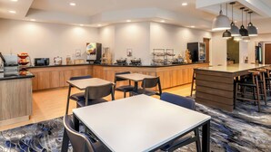A modern kitchen with wooden cabinets, a central island, and bar stools.