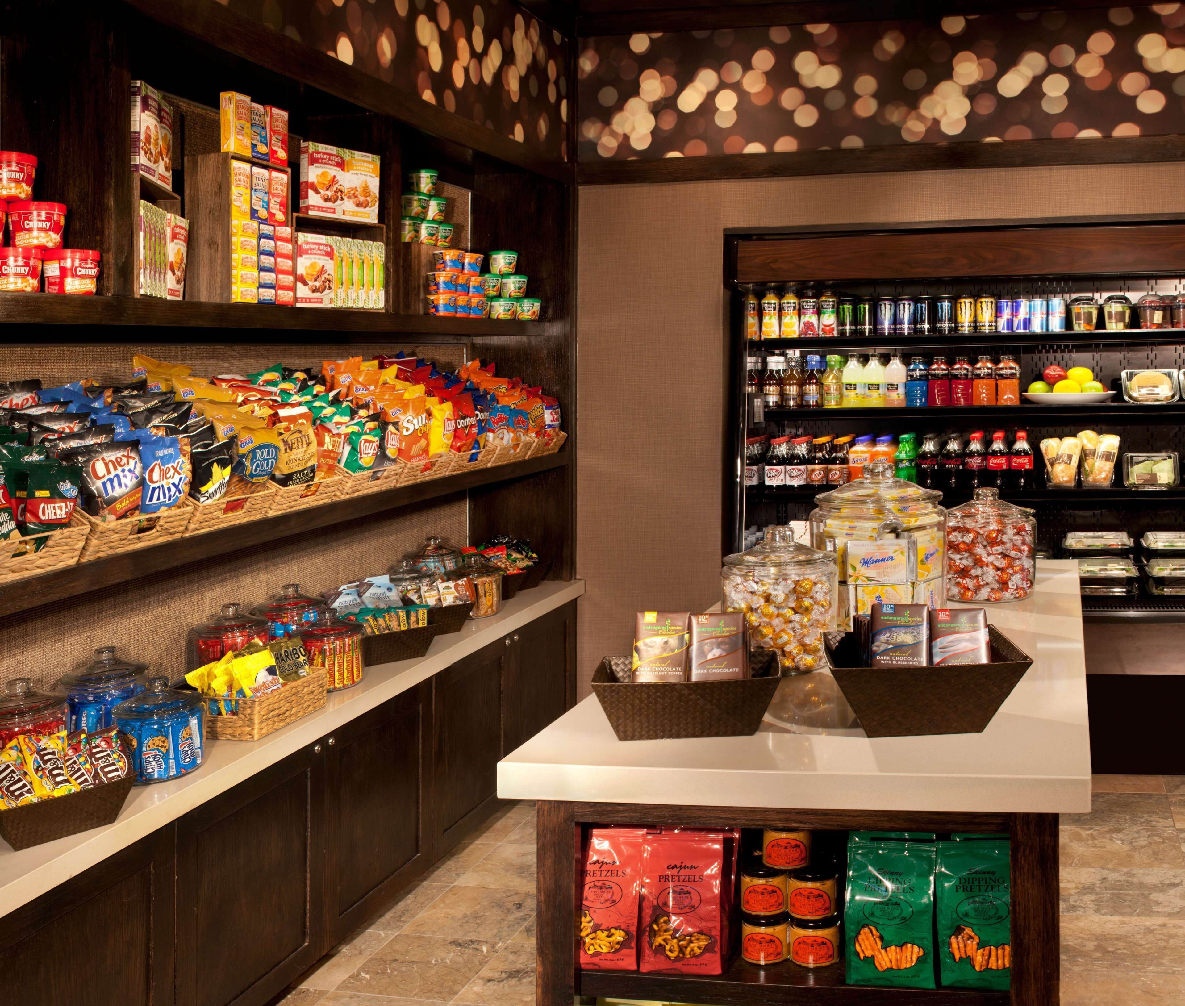 A well-stocked snack and beverage display in a store with various packaged goods and drinks.
