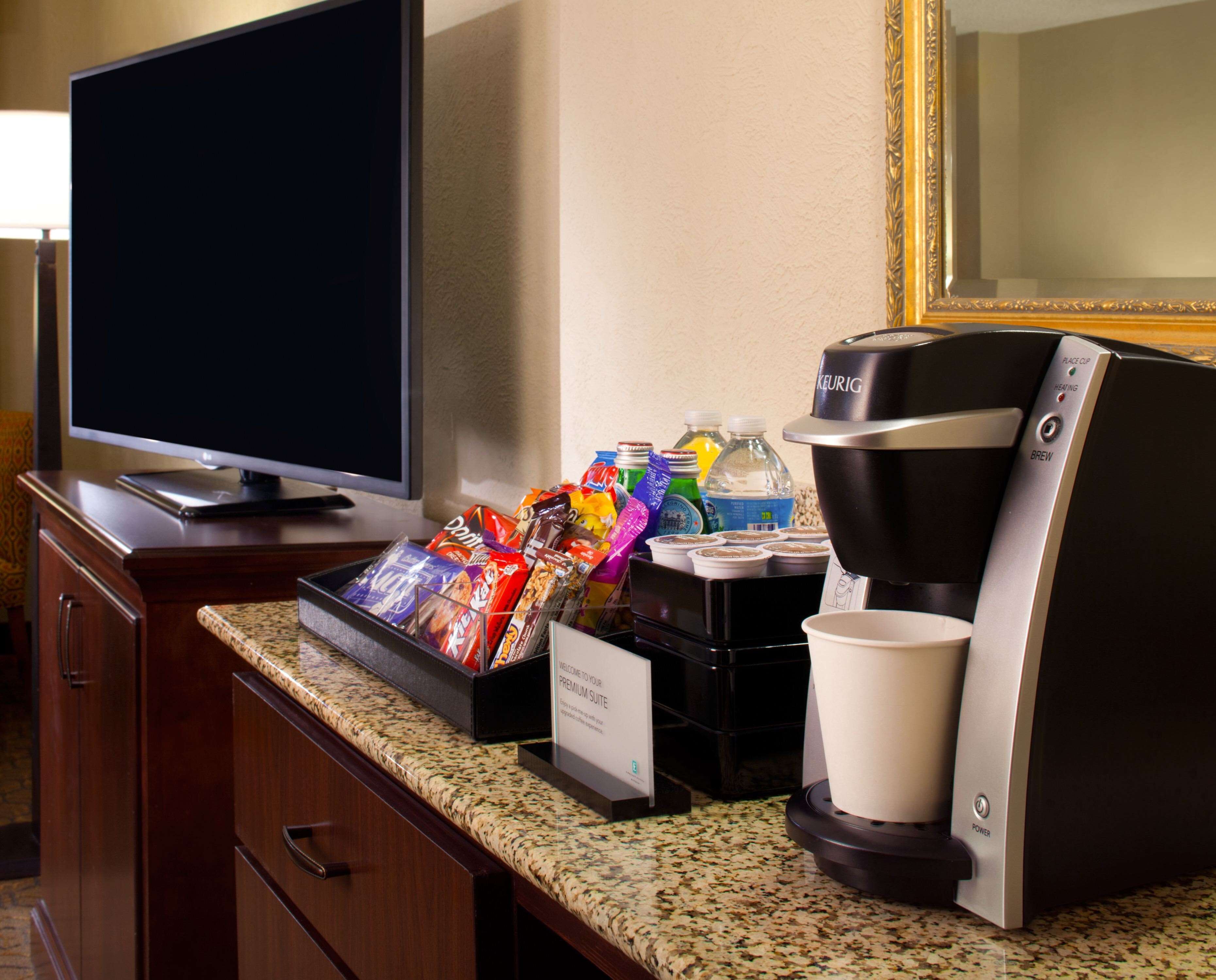 Une chambre d’hôtel équipée d’une machine à café, de quelques en-cas et d’un téléviseur.