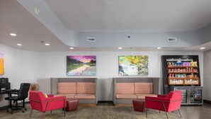 A lobby with two red sofas, a reception desk, and a snack vending machine. - Hampton Inn Carrollton (Carrollton)