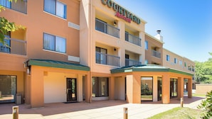 A Courtyard by Marriott hotel with a two-story structure, balconies, and a covered entrance area. - Courtyard by Marriott Boston Westborough (Westborough)