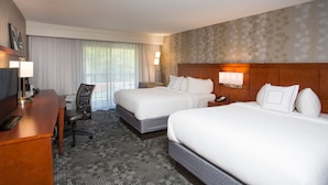 A hotel room with two beds, a desk, a chair, a lamp, and a window with curtains. - Courtyard by Marriott Boston Westborough (Westborough)
