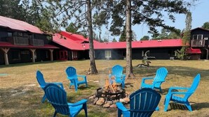 A fire pit with chairs arranged around it in an outdoor setting. - Northwestern Lodge (Hayward)