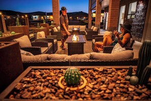 An outdoor seating area with wicker furniture, a fire feature, and cacti. - Kokopelli Inn Sedona, Trademark Collection by Wyndham (Sedona)
