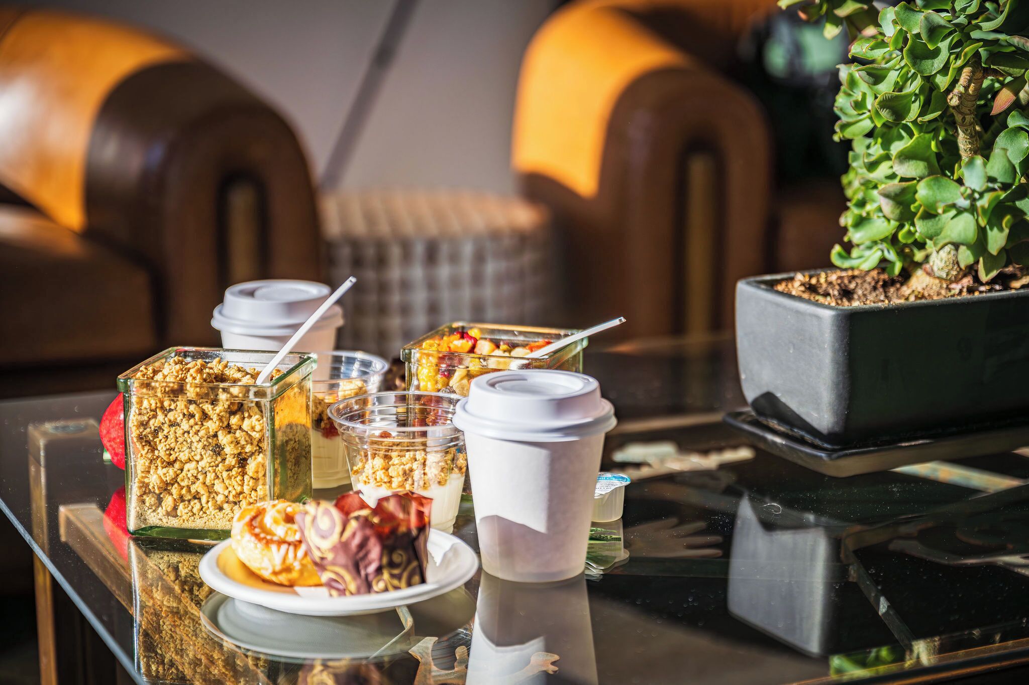 Ein Frühstücksbuffet mit verschiedenen Speisen und Getränken auf einer Glastischplatte.
