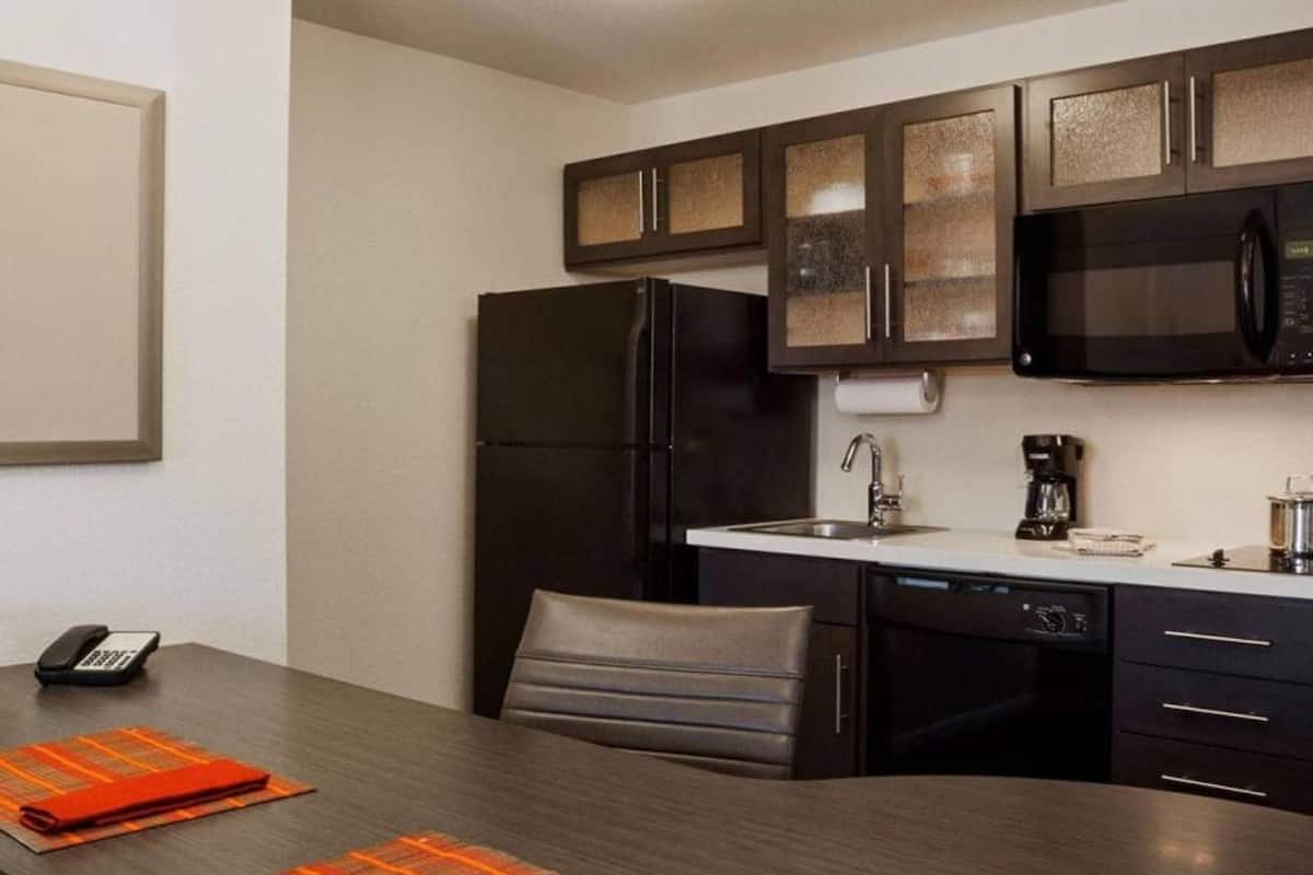 Una cocina compacta con refrigerador, microondas y lavavajillas.