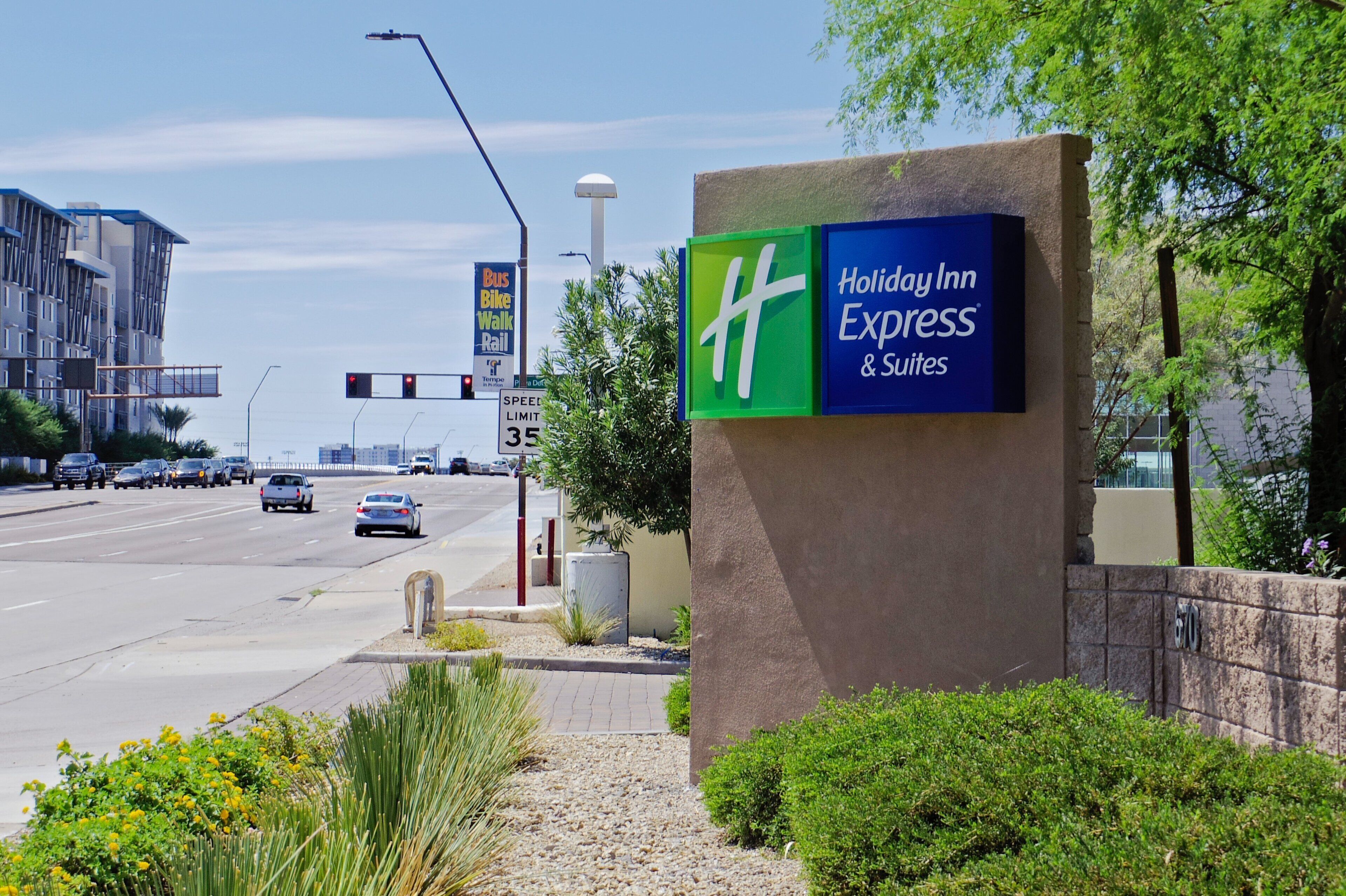 Señal de Holiday Inn Express & Suites junto a una señal de límite de velocidad de 35 millas por hora.