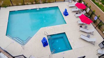 Alberca al aire libre, sombrillas en la alberca y camastros