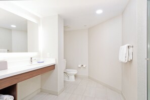Een moderne badkamer met een wit wastafel, toilet en douche.