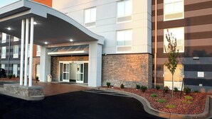 A Fairfield Inn & Suites hotel with a modern design, featuring a covered entrance and a landscaped area with small shrubs. - Fairfield Inn & Suites by Marriott Louisville Airport (Louisville)