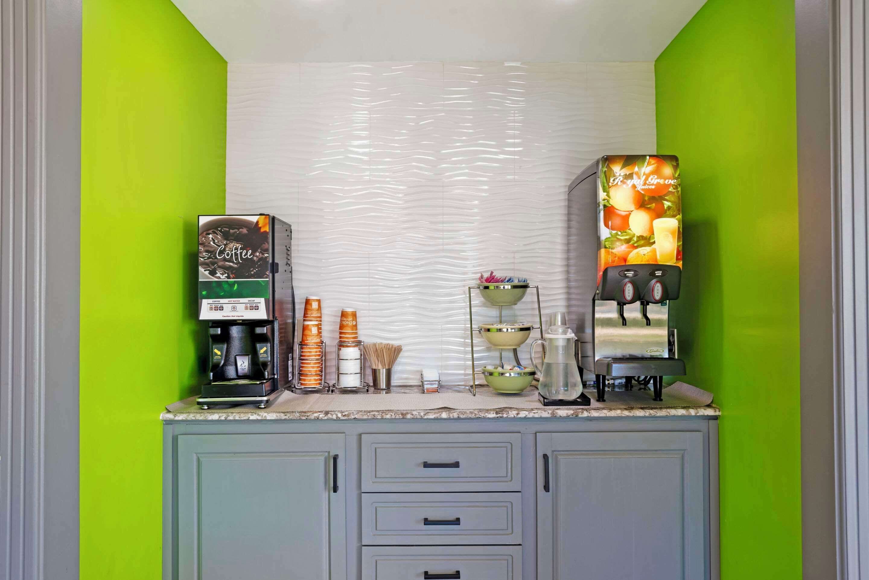 A kitchen with two coffee machines, a coffee maker, and various kitchen utensils on the counter.