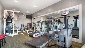 A gym with treadmills, weight machines, and a punching bag. - Quality Inn Brookhaven (Brookhaven)