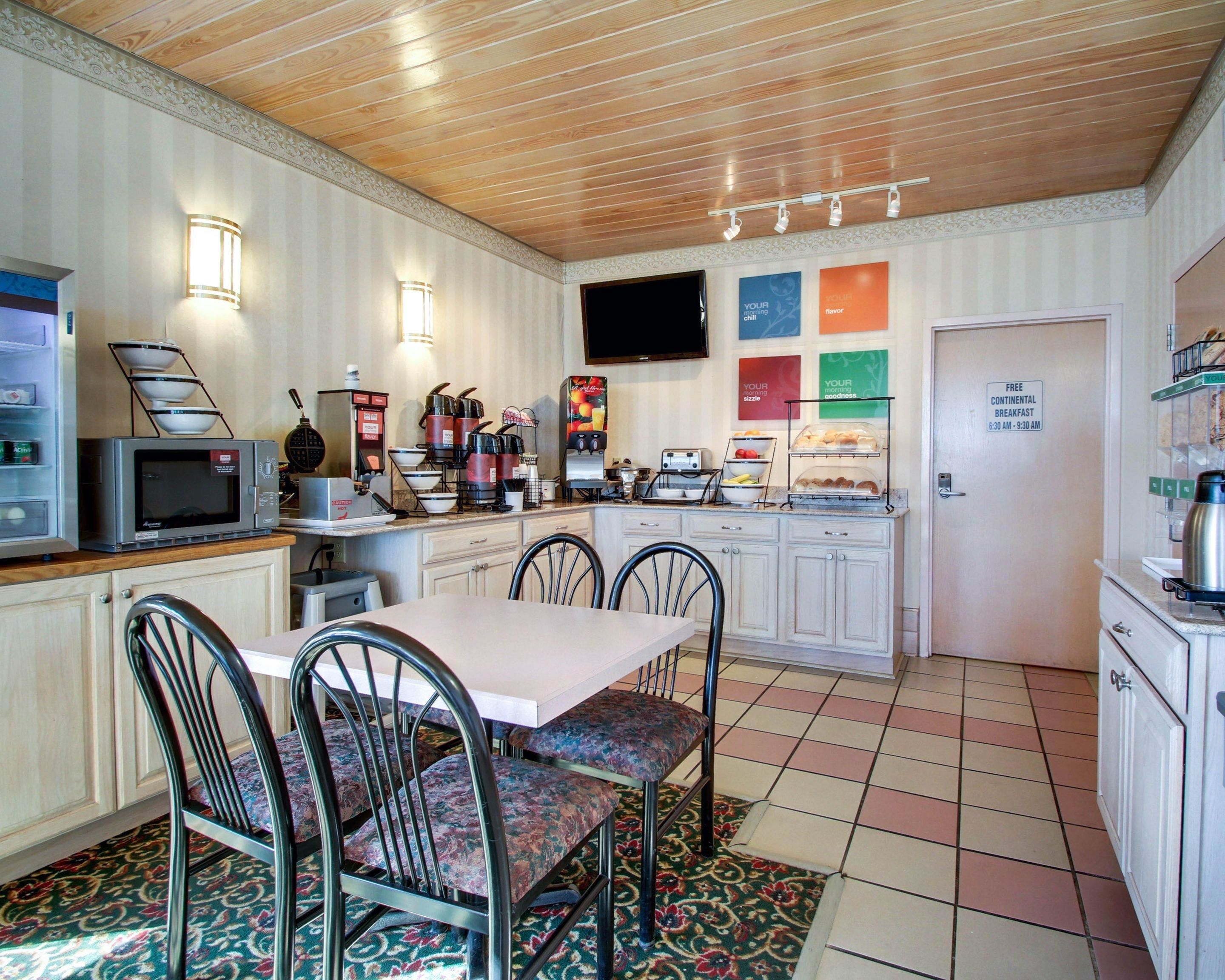 Cocina compacta con comedor, equipada con microondas, cafetera y tostadora.
