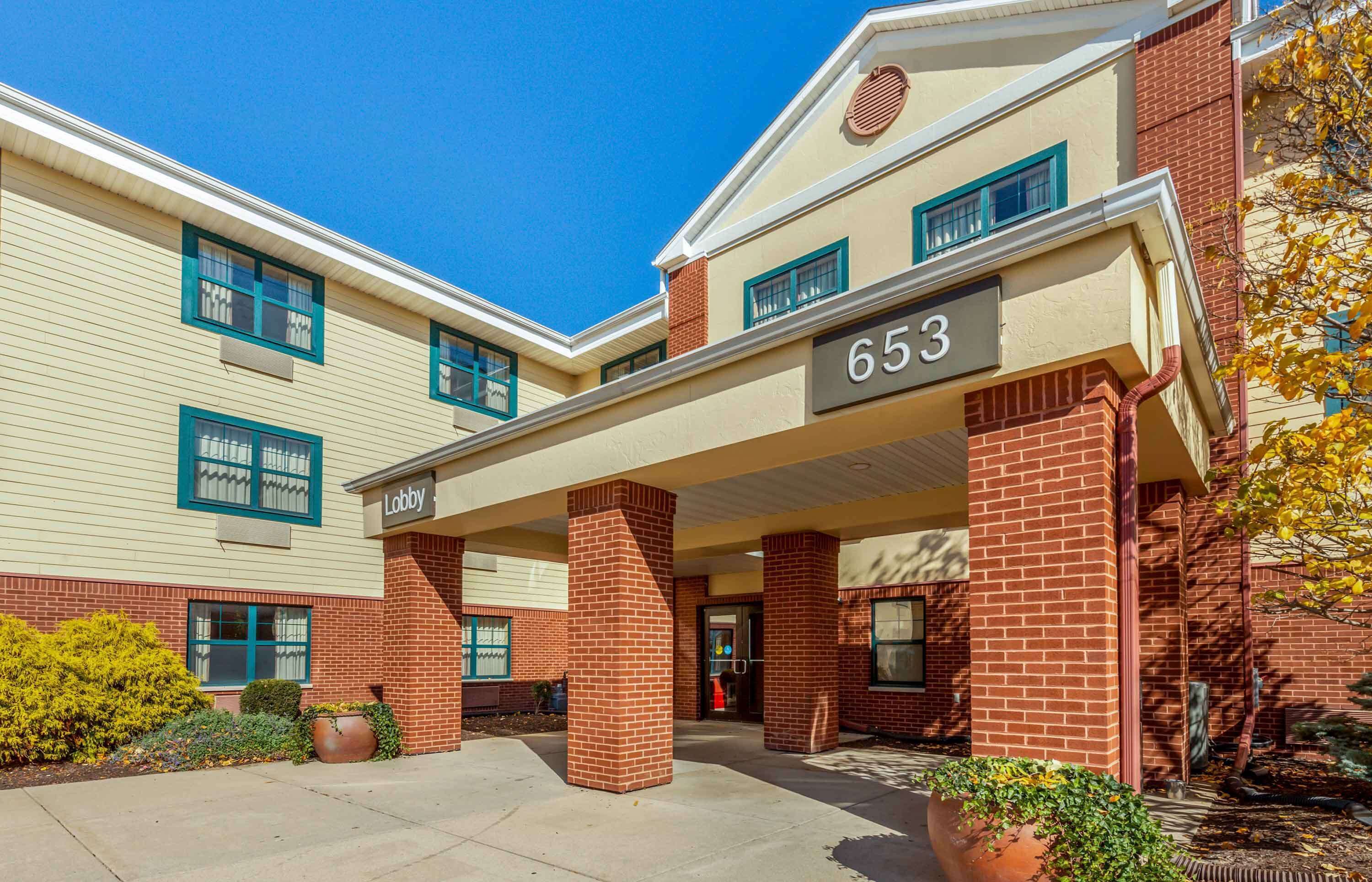 A building with a beige exterior, a brick entrance, and a sign reading "653 Lobby".