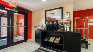 A hotel lobby with a coffee station, a reception desk, and a wheelchair-accessible exit.