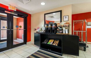 Un hall de hotel con una estación de café, una recepción y una salida accesible para sillas de ruedas.