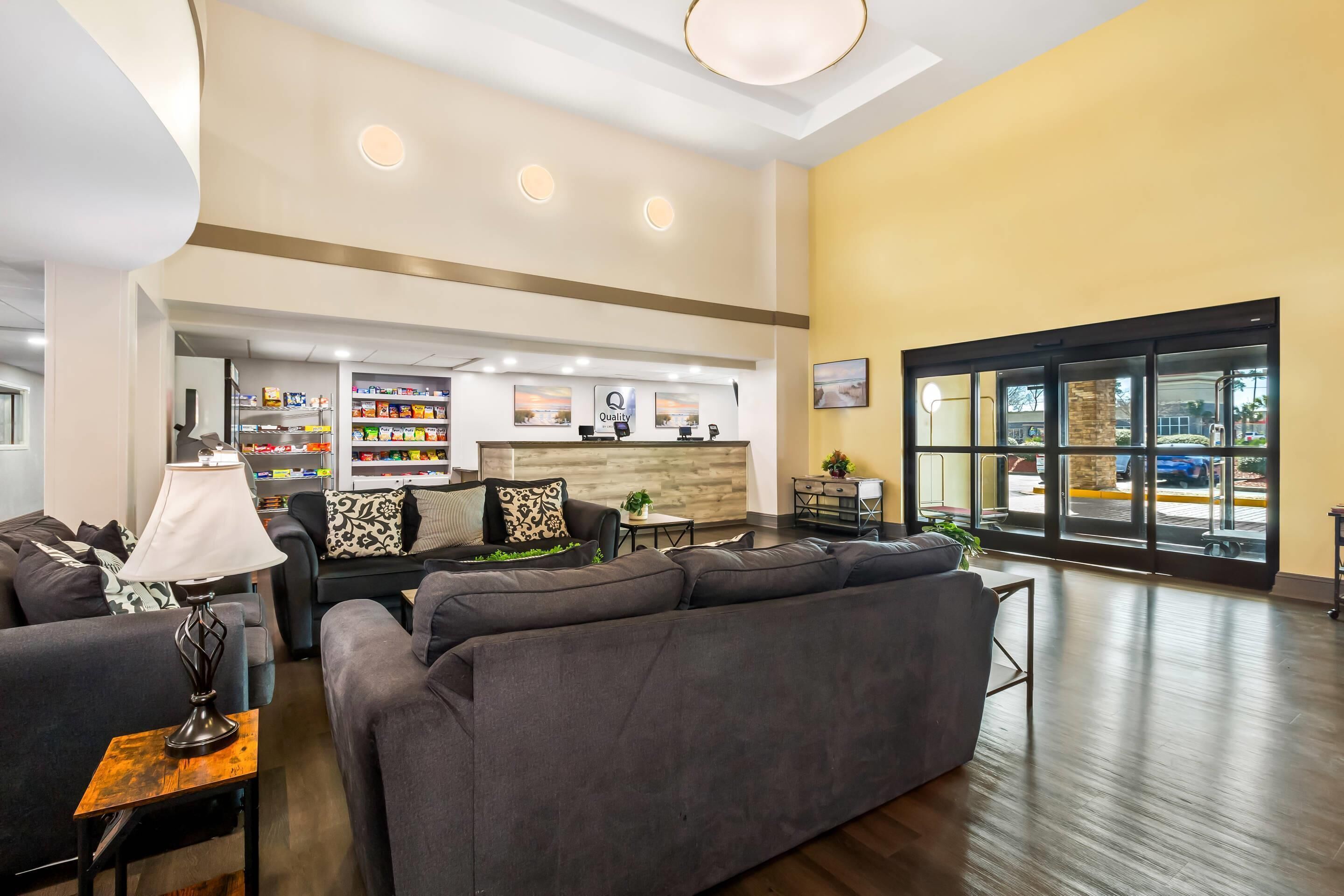 A spacious lobby with a reception desk, seating area, and a large window offering a view of the outside.