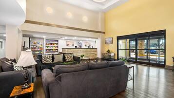 A spacious lobby with a reception desk, seating area, and a large window offering a view of the outside.