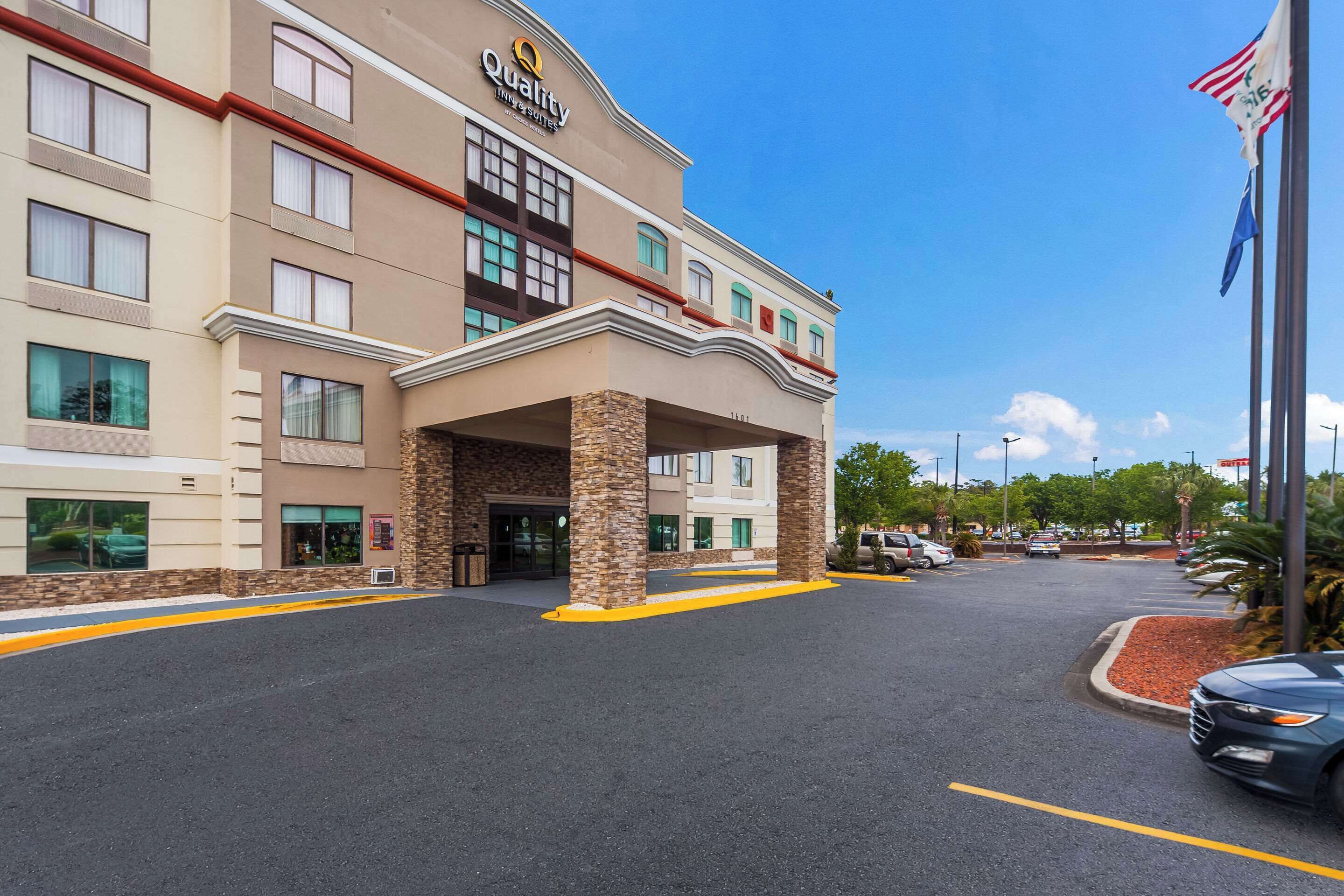 A hotel with a beige facade, multiple windows, and a stone entrance.