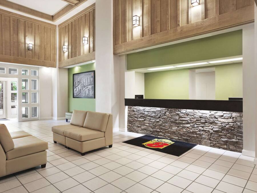 A lobby with a stone wall, beige sofas, and a reception desk.