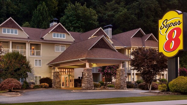 A hotel with a covered entrance, stone pillars, and a sign reading "Super 8". - Super 8 by Wyndham Cherokee (Cherokee)