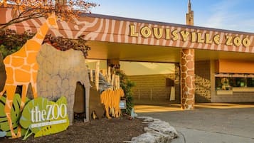 La entrada al Zoológico de Louisville, con una escultura de jirafa y un cartel.