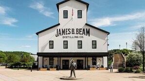 A building with "James B. Beam Distilling Co." signage, a statue in front, and a clear sky. - Comfort Inn Shepherdsville - Louisville South (Louisville)