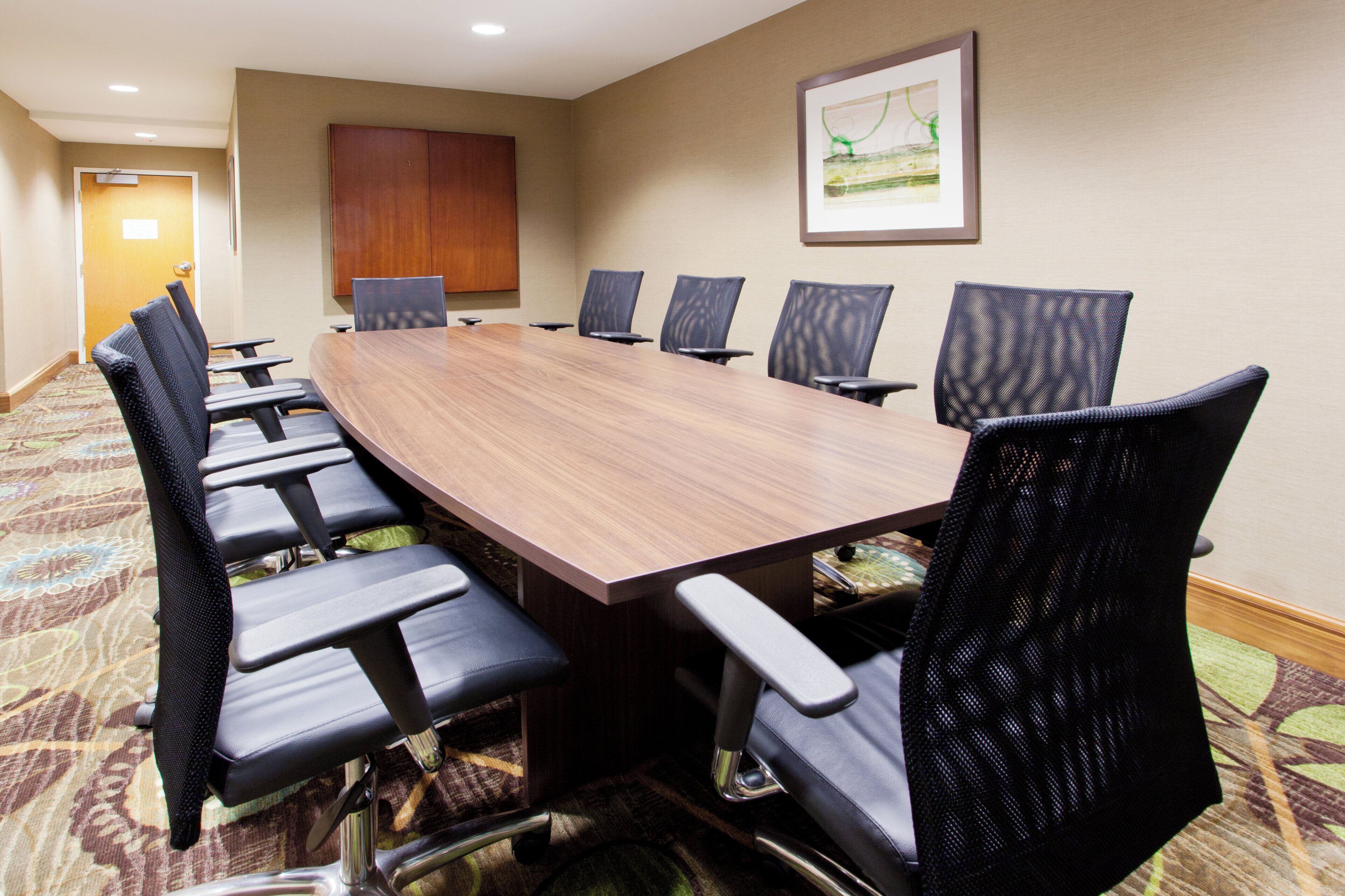 A conference room with a long table and eight chairs.