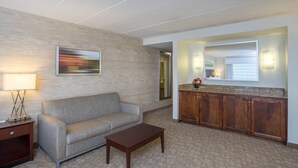 Eine Hottelevestibül mit einer Couch, einem Holztisch, einer Holzkommode und einem Bild an der Wand.