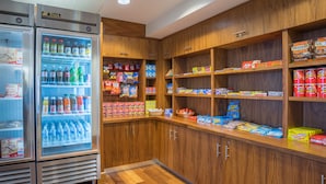 Ein ordentlich sortierter Bereich für Snacks und Getränke, mit gekühlten Getränken und verschiedenen verpackten Snacks.