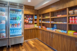 Una zona bien organizada para aperitivos y bebidas, con opciones de bebidas frías y una variedad de bocadillos empaquetados.