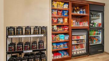 A snack and beverage section with shelves stocked with various snacks, bottled drinks, and packaged foods.
