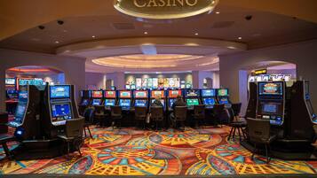 A casino with multiple slot machines and a colorful carpet.