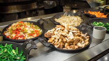 A kitchen counter with various food items including vegetables and mushrooms.
