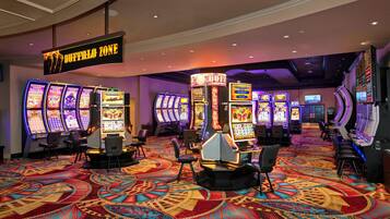 A casino area with multiple slot machines, a sign indicating the 'Buffalo Zone', and a carpeted floor with a geometric pattern.