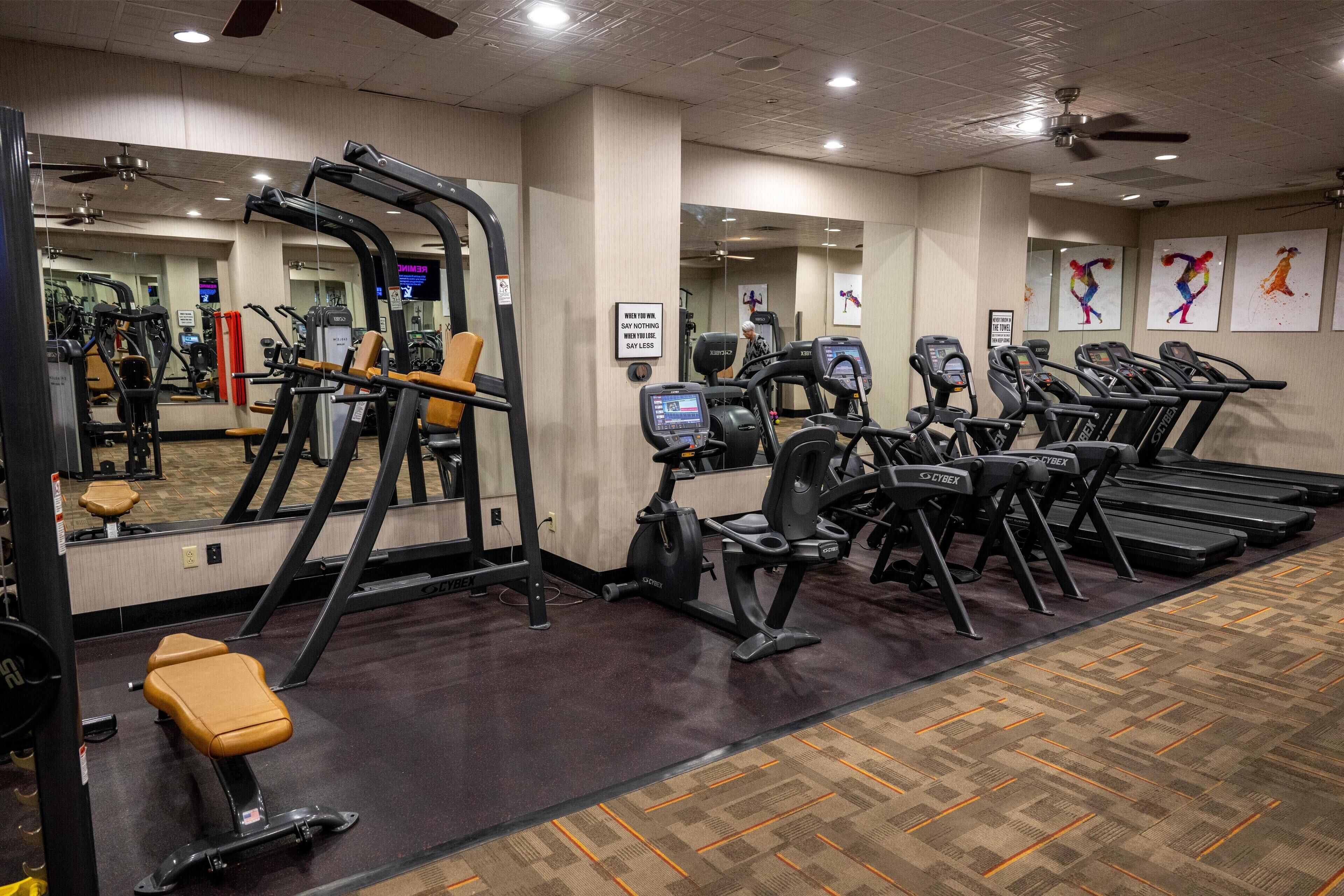 A gym with treadmills, exercise bikes, and weight machines.